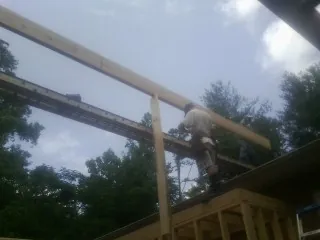 Carpenter setting a ridge beam over a new addition frame — Ice Dam Removal by Roofing Brothers in Blue Ridge Summit