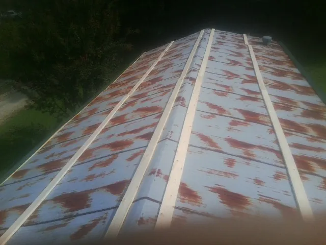 Rusted metal roof panels with new wood purlins before replacement — Storm Damage Roof Repair in Blue Ridge Summit by Roofing Brothers