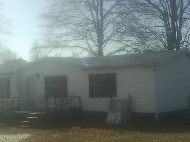 New metal roof on a white painted brick home on a foggy morning in Blue Ridge Summit